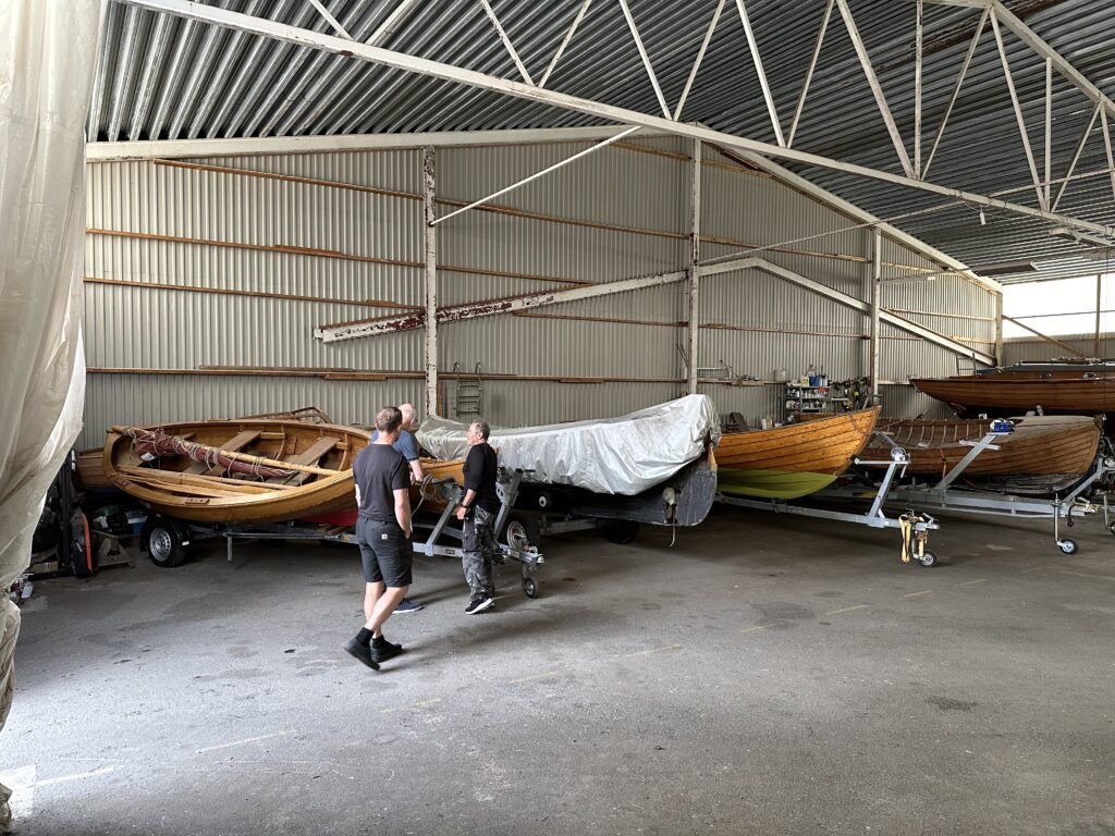 Det var mycket att se. I ett stort hangar fanns ytterligare båtar. Sten Carlsson guidar oss i föreningens stora hangar. Foto: Martin Prieto Beaulieu