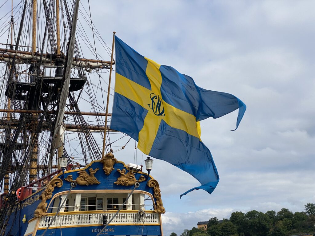 SOIC-flaggan fyller vinden över Ostindiefararen Götheborgs rikt ornamenterade akter – 1700-talets sjöfart i modern tappning. Foto: Martin Prieto Beaulieu
