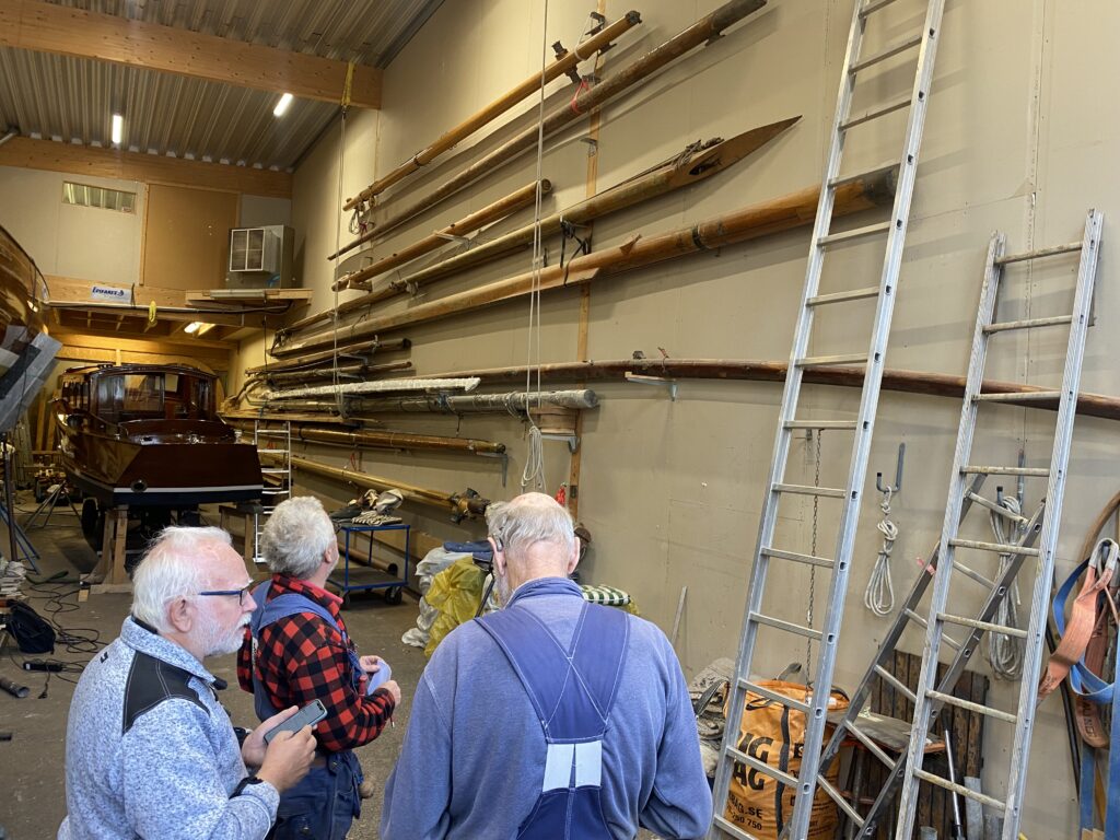 Renoveringsfonden har en mastbank – master och annat rundhult som fonden genom åren samlat in för vidare förmedling. Delar som annars riskerat att eldas upp får nytt liv på nya båtar. På bild: Hans Samuelsson, Tor Hedvall och Thomas Larsson. Foto: Martin Prieto Beaulieu