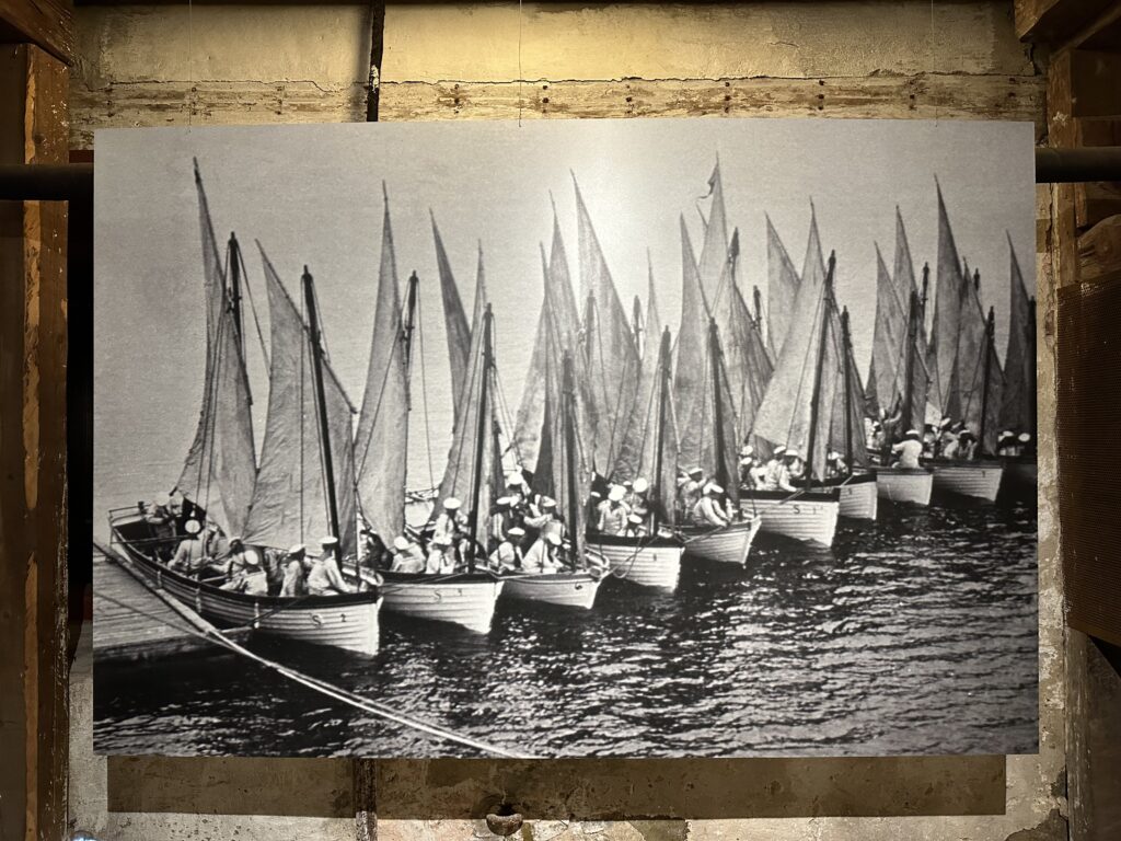 I Marinmuseums utställning om marinens slupar, barkar och andra mindre båtar hänger denna bild, där bland annat barkassen Falken, Biskopen, Biskopinnan och flera andra båtar syns. Foto: Martin Prieto Beaulieu