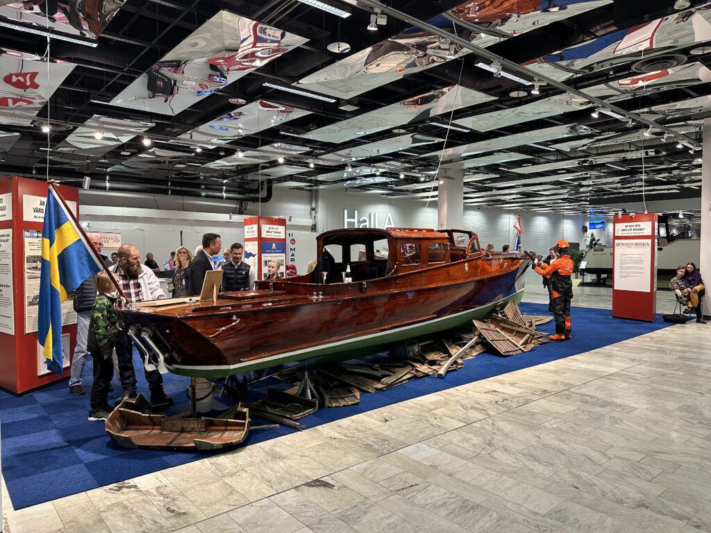 Raket prydde Heleneborgs Båtklubbs monter på båtmässan Allt för Sjön 2023 i Stockholm. Skyltdockan med motorsåg visualiserar hotet mot många av våra äldre träbåtar – att de riskerar att försvinna genom upphuggning. Foto: Martin Prieto Beaulieu